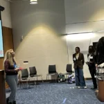 Jenna congratulating the Spring 2025 cohort of Duke's Cognitive Neuroscience Research Internship during their final poster presentations.